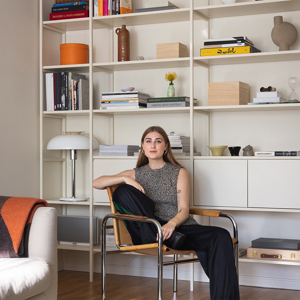 bokhylla i off white med lampa och böcker